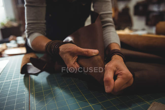 Meia-seção de artesã trabalhando em um pedaço de couro na oficina — Fotografia de Stock