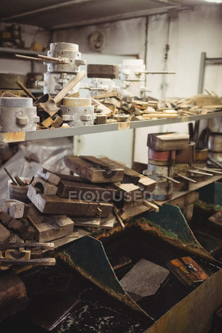 Металеві та дерев'яні форми для дмелення скла, розташовані на полиці на скляному заводі — стокове фото