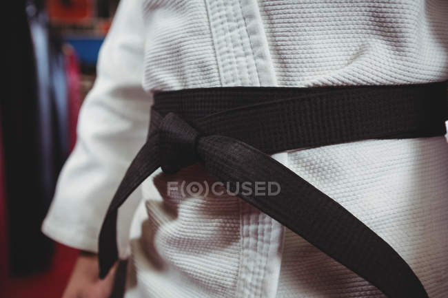 Mid section of karate player in black belt — Stock Photo