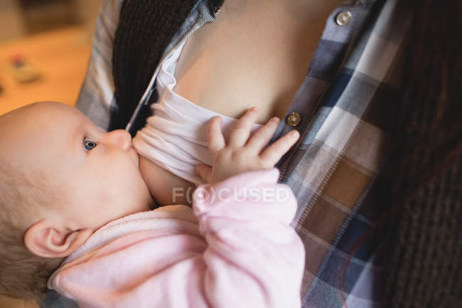 Close-up of mother breastfeeding baby at home — Stock Photo