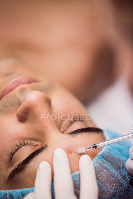Uomo che riceve un'iniezione di botox sulla fronte in clinica — Foto stock