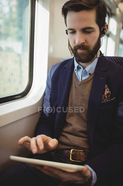 Empresário usando tablet digital enquanto viaja no trem — Fotografia de Stock