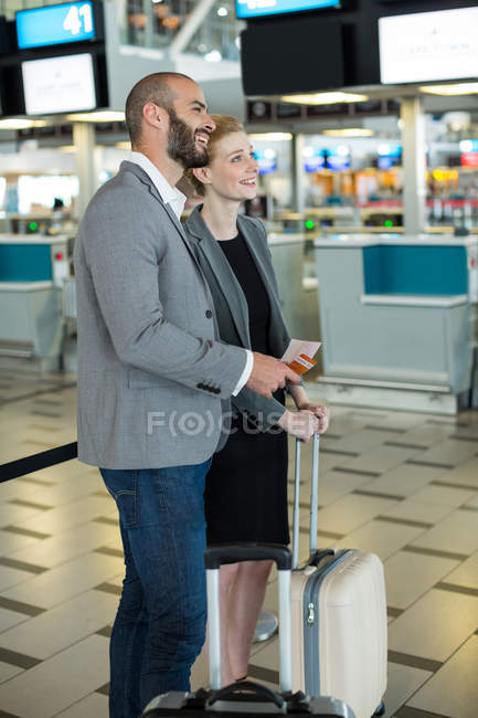 Uomini d'affari in fila al banco del check-in con i bagagli nel terminal dell'aeroporto — Foto stock