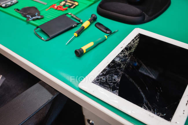 Close-up of damaged digital tablet in service centre — Stock Photo