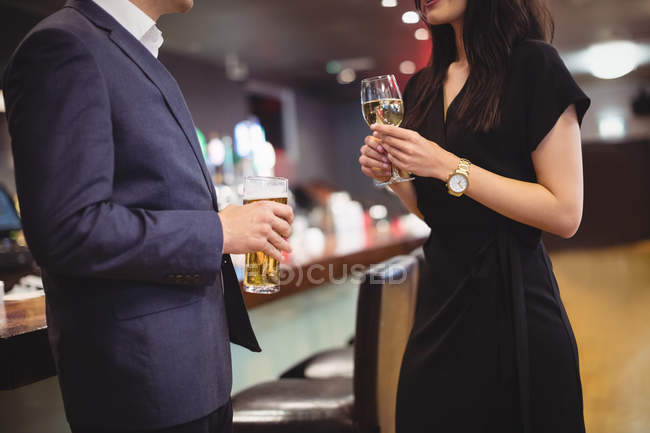 Средняя часть пары выпивает вместе в баре — стоковое фото