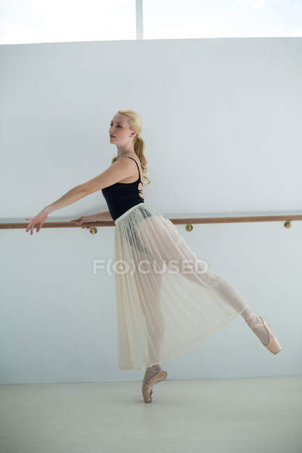 Балерина розтягування Барре під час практикуючим балету танцю в студії — стокове фото