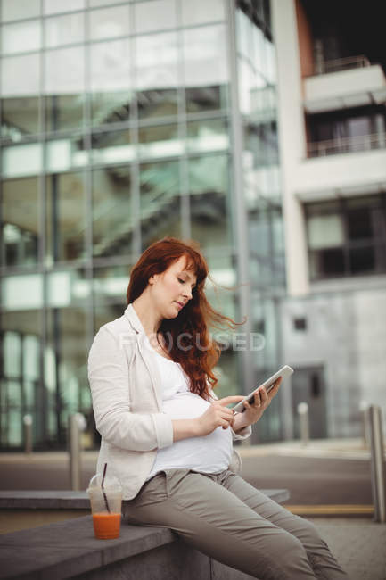 Grávida empresária usando tablet digital em instalações de escritório — Fotografia de Stock