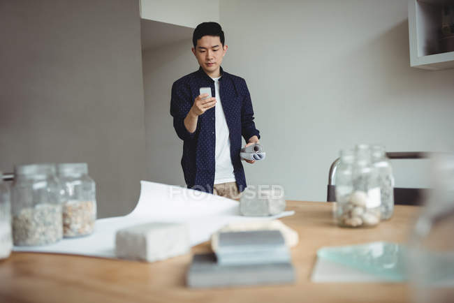 Geschäftsführender Angestellter mit Handy im Büro — Stockfoto