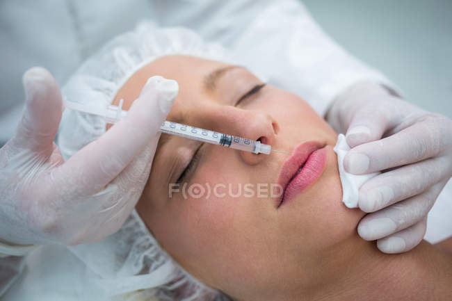 Крупним планом жіночий пацієнт отримує ін'єкції ботокса на губах — стокове фото