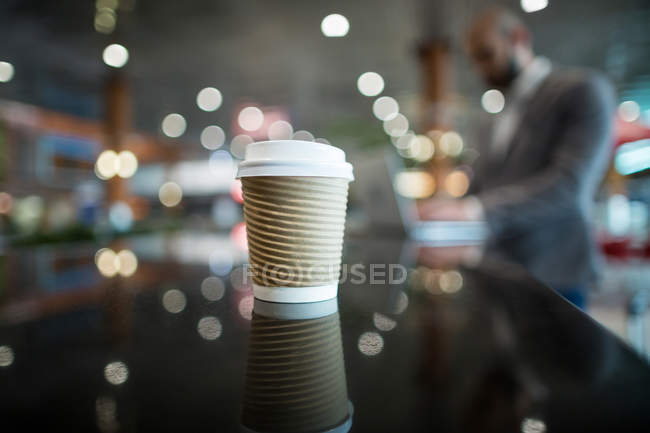 Primer plano de la taza de café en el mostrador en la terminal del aeropuerto - foto de stock