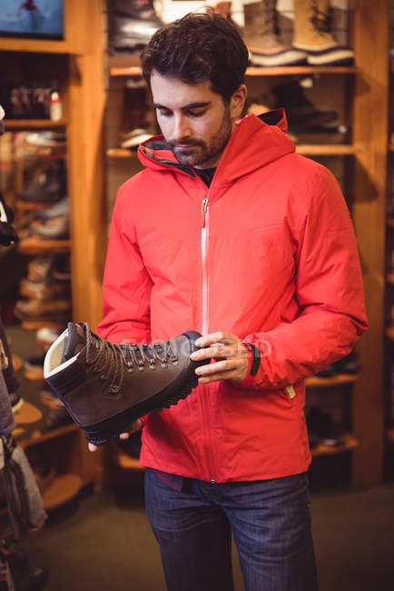 Hombre guapo seleccionando zapato en una tienda - foto de stock