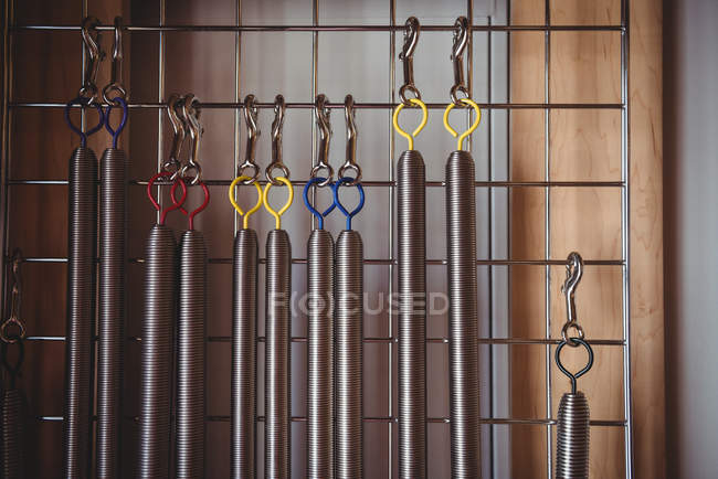 Various exercise equipment hanging on frame in fitness studio — Stock Photo