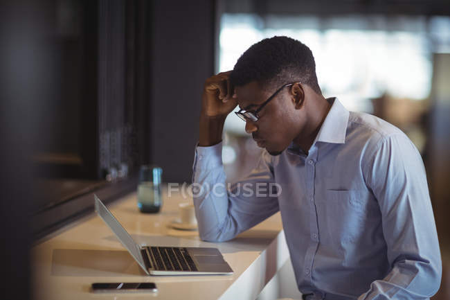 Uomo d'affari che utilizza laptop in ufficio — Foto stock