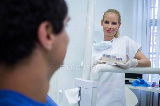Female doctor standing and holding box at clinic — Stock Photo