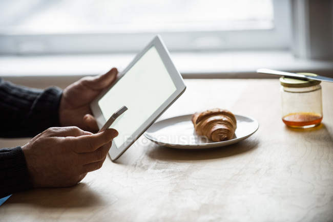 Mann nutzt digitales Tablet und Handy zu Hause — Stockfoto