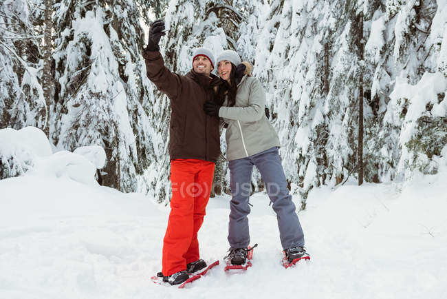 Feliz pareja de esquiadores tomando una selfie en la montaña cubierta de nieve - foto de stock