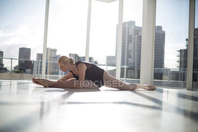 Bailarina fazendo exercício de alongamento no estúdio de balé — Fotografia de Stock