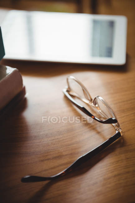 Brille und digitales Tablet auf Holztisch zu Hause — Stockfoto