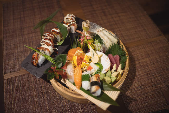 Various sushi in bamboo sushi plate in restaurant — Stock Photo