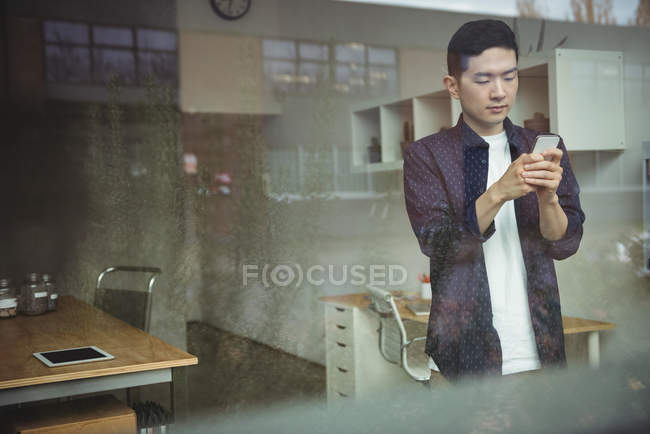 Geschäftsführender Angestellter mit Handy im Büro — Stockfoto