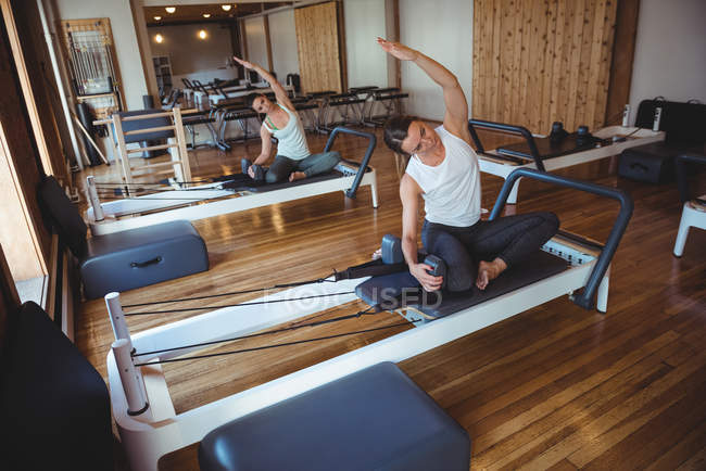 Women practicing pilates on reformers in fitness studio — Stock Photo