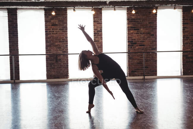 Молода жінка практикує сучасний танець в танцювальній студії — стокове фото