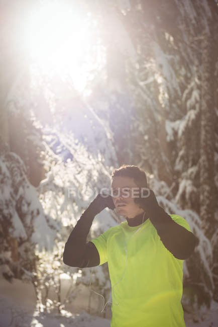 Homem atencioso de pé na floresta durante o inverno — Fotografia de Stock