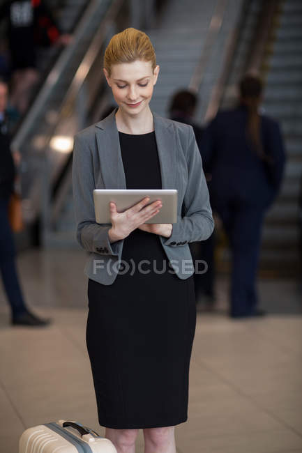 Деловая женщина с помощью цифрового планшета в аэропорту — стоковое фото