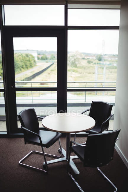 Пустой круглый стол и стулья в офисе — стоковое фото