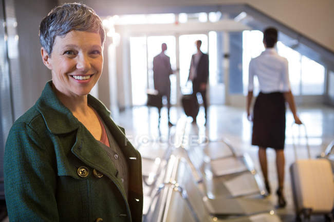Портрет жінки, яка посміхається в терміналі аеропорту — стокове фото