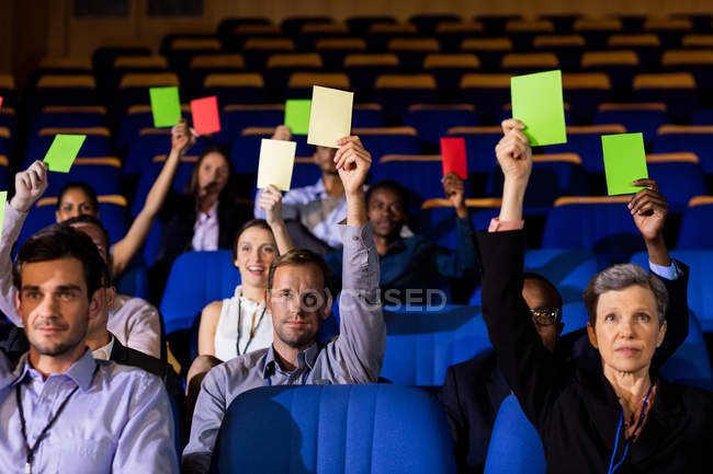 Führungskräfte zeigen Zustimmung, indem sie im Konferenzzentrum die Hände heben — Stockfoto