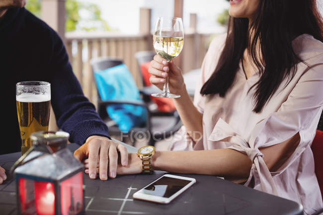 Seção intermediária de casal tomando bebidas juntos no restaurante — Fotografia de Stock