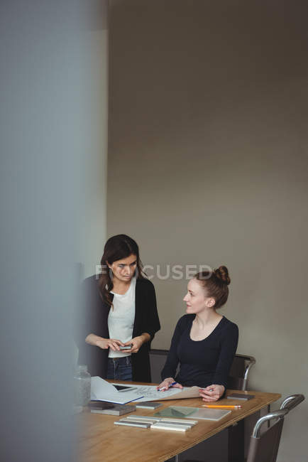 Business executives interacting with each other in office — Stock Photo