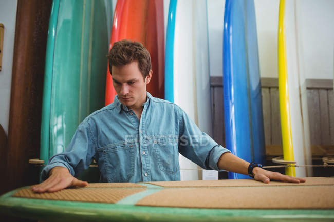 Чоловічий тесляр робить дошку для серфінгу в інтер'єрі майстерні — стокове фото