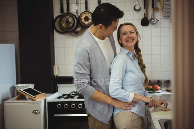 Paar umarmt sich in Küche zu Hause — Stockfoto