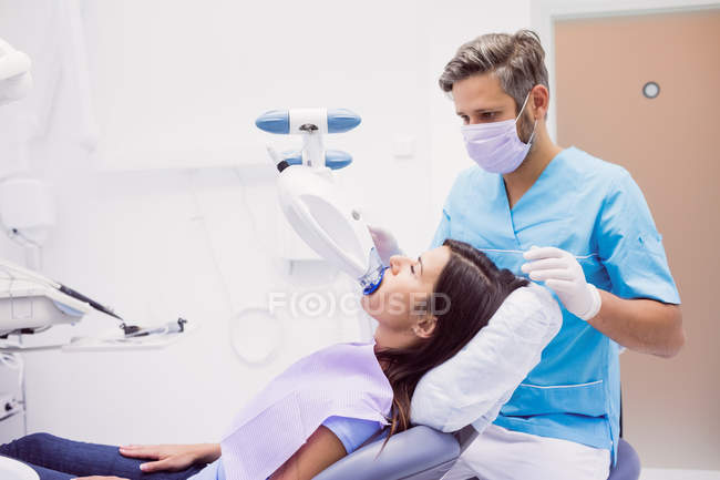 Пациентка, получающая лечение зубов от мужского ортодонта в стоматологической клинике — стоковое фото