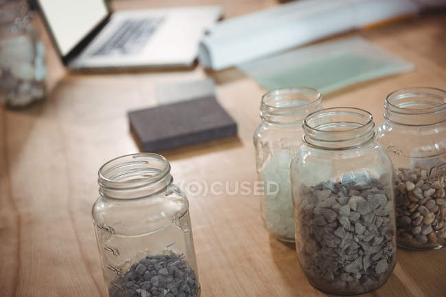 Probe von Kieselsteinen im Glas auf dem Tisch im Büro — Stockfoto