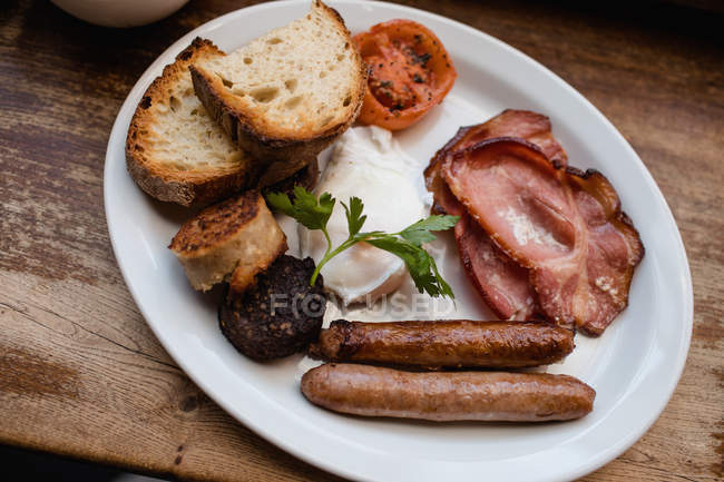 Close-up of English breakfast with black pudding on plate on table — Stock Photo