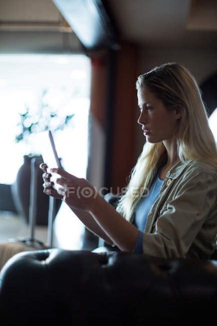 Красивая женщина с цифровым планшетом в зоне ожидания в терминале аэропорта — стоковое фото