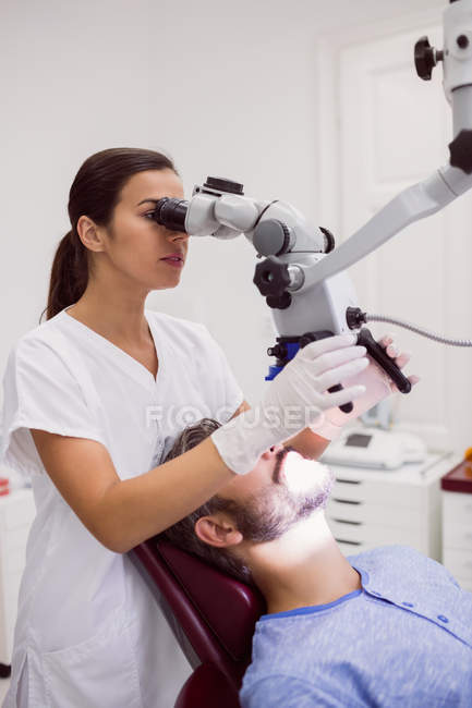 Жіночий стоматолог оглядає пацієнта в клініці — стокове фото