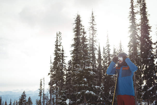 Hombre usando casco contra árboles durante el invierno - foto de stock