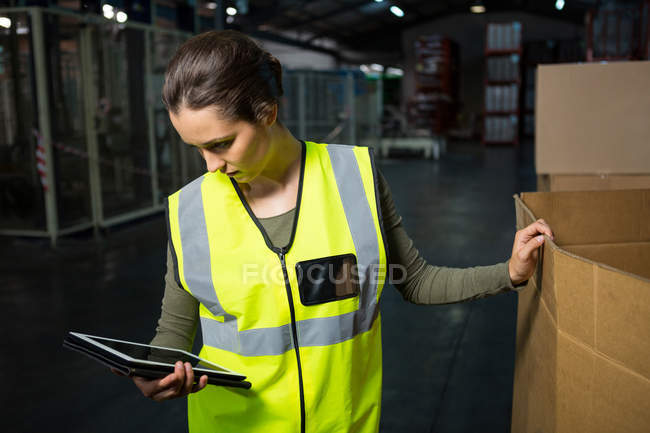 Серйозні жіночий працівника допомогою планшетного ПК у склад — стокове фото
