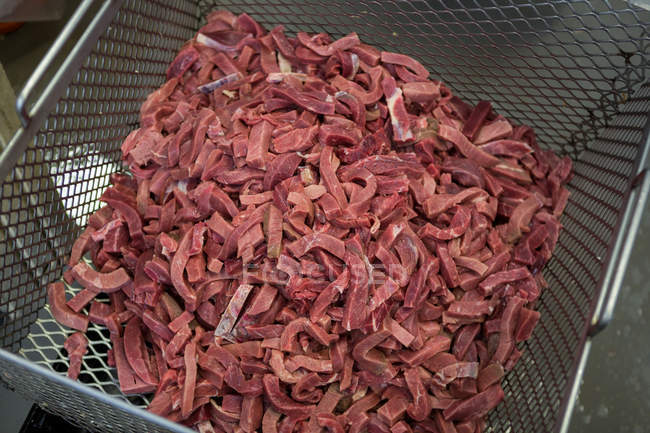 Pedaços de carne crua em recipiente na fábrica de carne — Fotografia de Stock