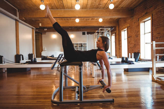 Femme déterminée à pratiquer pilates en salle de fitness équipement d'exercice — Photo de stock