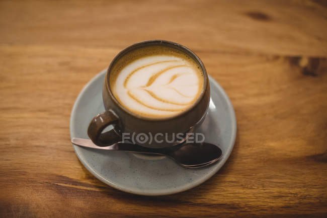 Крупный план чашки кофе капучино с ложкой на блюдце — стоковое фото