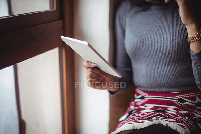 Mid-section of woman using digital tablet in cafe — Stock Photo
