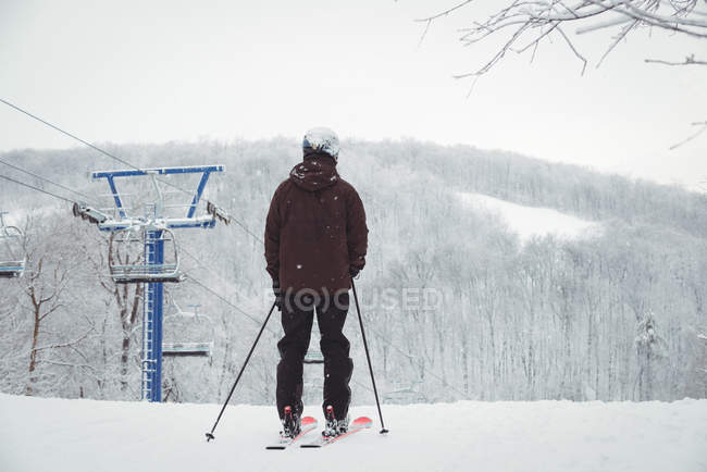 Hombre de pie en la cima de la montaña - foto de stock