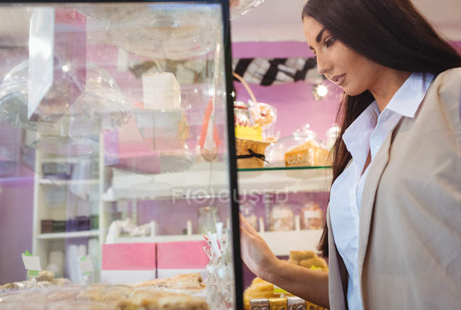 Красивая женщина, смотрящая на турецкие сладости в магазине — стоковое фото