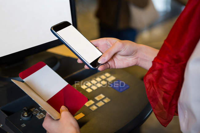 Close-up of female scanning the boarding pass with mobile phone — Stock Photo