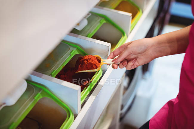 Close-up of shopkeeper holding spice scoop in shop — Stock Photo